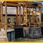 Trash rack cleaning machine removing debris from water intake